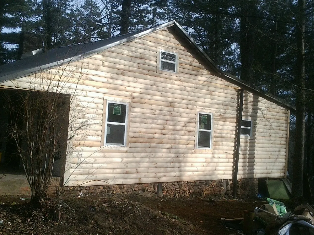 New log siding and dark metal roofing on a gable end in New Waverly