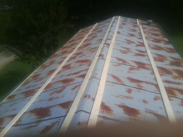 Rusted metal roof panels with new wood purlins before replacement — Storm Damage Roof Repair in New Waverly by Roofing Brothers