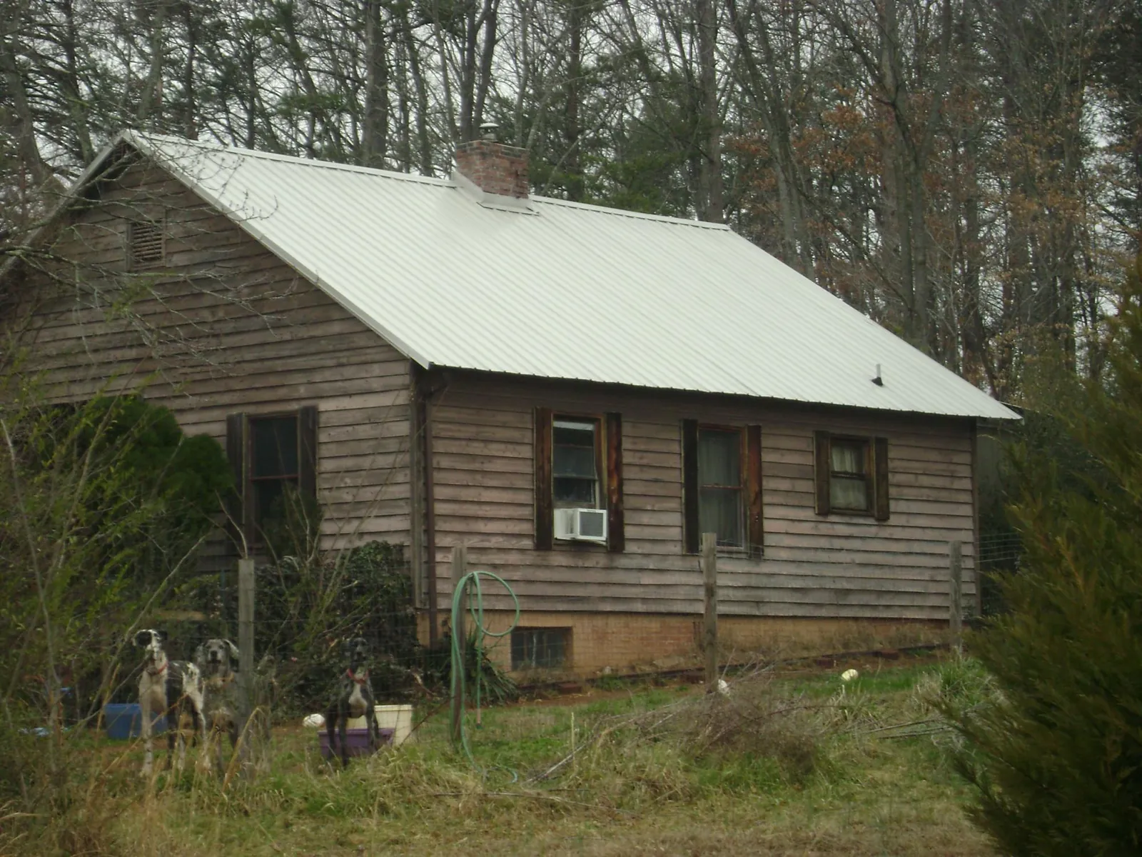 White metal roof on an old wood sided farmhouse, from a Metal Roof Installation job in New Waverly